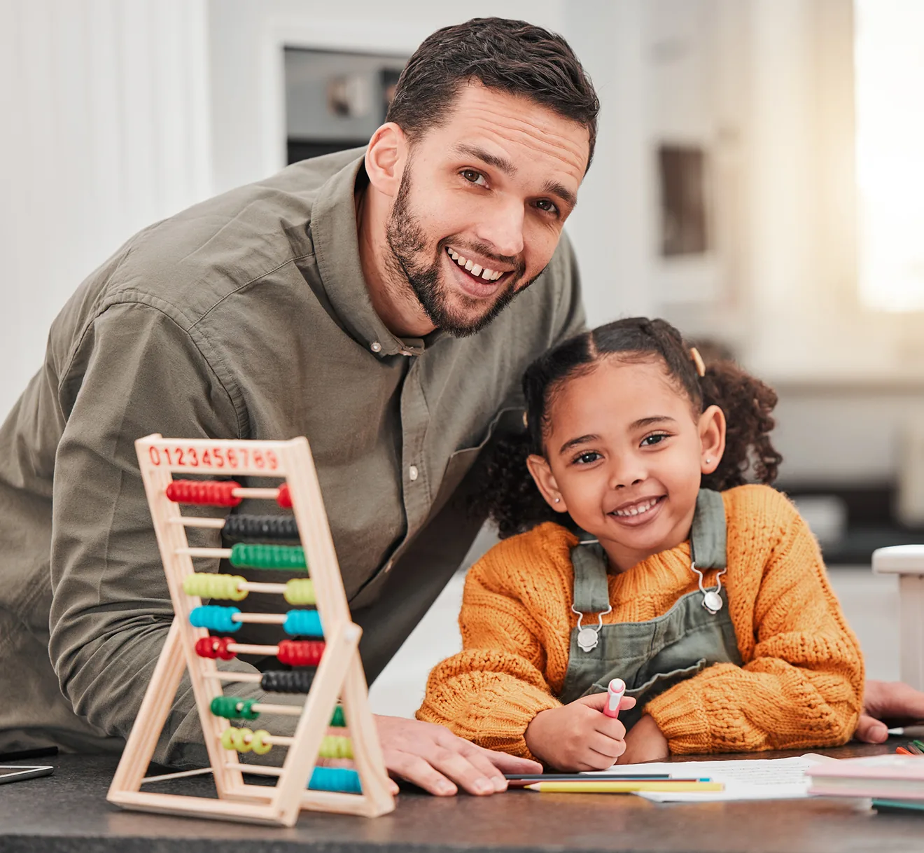 An adult and a child working together with a wooden counting frame